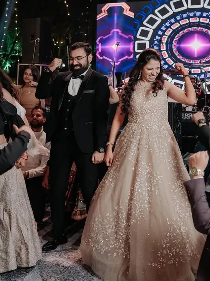 The couple surrounded by their friends on the dance floor, a classic Sangeet moment.