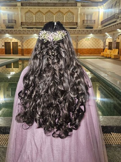A view of the beautiful, flowing hairstyle from the back, adorned with baby's breath. It's romantic and perfect for a Haldi.