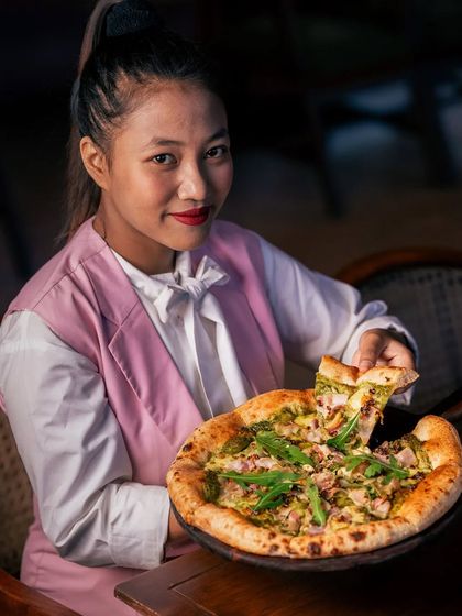 What happens when madcap innovation meets strict Italian training? You get the finest pizzas in the city, like this one with pesto and savory toppings.