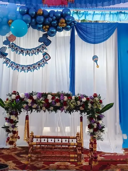 Here is a beautiful setup for a traditional Namakarana or naming ceremony. We decorated the wooden cradle, or thottilu, with fresh flowers and created a backdrop with blue balloons and soft white drapes to welcome the little one.