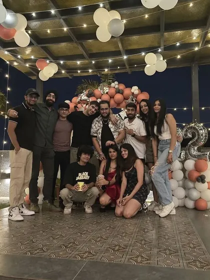 The whole crew together. A group photo in front of the birthday decor captures the memory of a fun night celebrating a 22nd birthday.