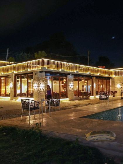 The entire cafe and pool area lit up at night. I designed the lighting to create a warm, luxurious, and inviting atmosphere for our evening guests.