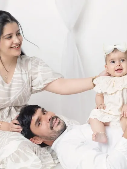 A playful and fun pose with dad lying down and the baby sitting on his tummy. It's a great way to get genuine laughs.