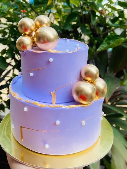 I love creating these mini two-tier cakes for intimate New Year celebrations. This elegant lavender cake is decorated with gold spheres and pearl details for a touch of glamour.