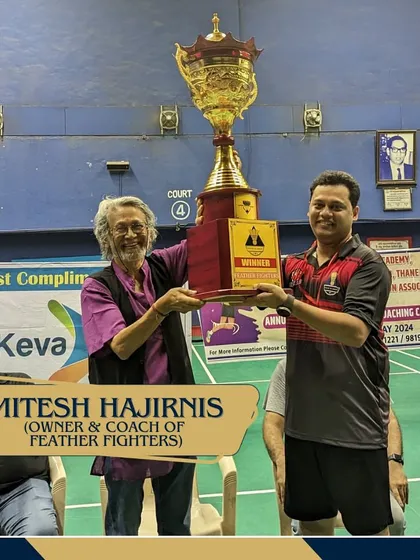 A moment of triumph for Mitesh Hajirnis, owner of the winning team Feather Fighters, as he lifts the championship trophy.