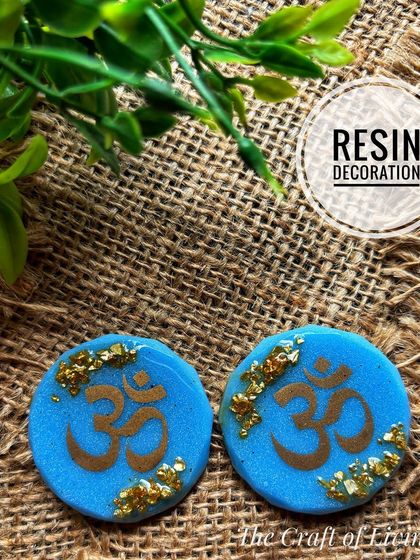 A set of blue resin discs with the 'Om' symbol in gold. These can be used as decorative pieces or magnets to bring a sense of peace and spirituality to your space.