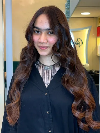 A happy client showing off her new rich, chocolate-colored hair. It perfectly complements her features.