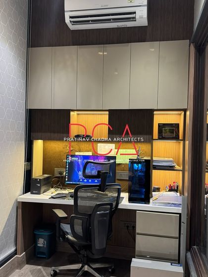 The compact study or gaming nook attached to the son's room, featuring built-in overhead storage and display shelves with integrated lighting.