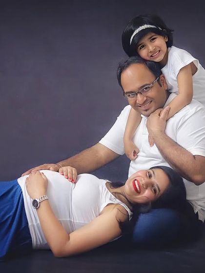 Our family is growing and so is the love! A fun and happy pose during a studio maternity session, with their daughter giving her dad a big hug.