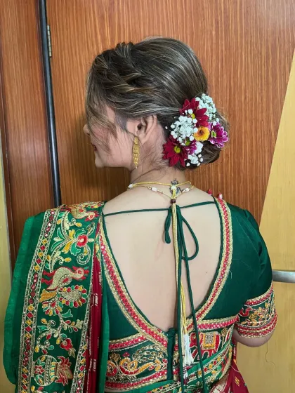 A beautiful, intricate bun adorned with a mix of colorful fresh flowers, perfect for a wedding or pre-wedding function.
