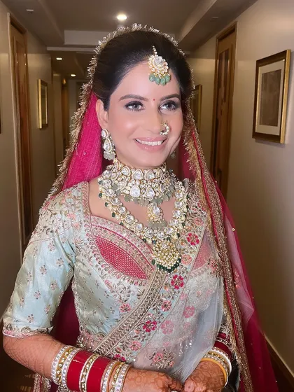 A happy bride in her pastel blue and pink lehenga, showing that traditional looks can also be soft and colorful. Her smile is our biggest reward.