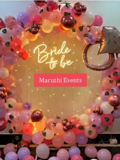 A trendy and fun 'Bride to be' party decoration. This features a circular balloon arch in shades of pink, a custom neon sign, and a large diamond ring foil balloon, creating the perfect glamorous backdrop for a bachelorette party or bridal shower.