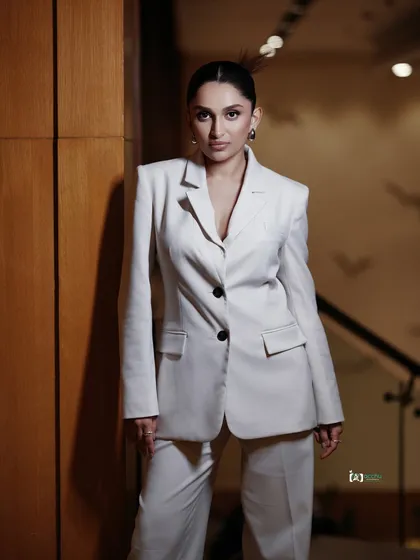 Power dressing is an attitude. For this studio portrait, we went for a clean, sharp look with a white power suit. The focus is on the confident posture and direct gaze, creating a 'boss mode' vibe that’s both elegant and strong.