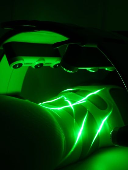 This image captures the precise action of the Emerald Laser on the thigh area. The intersecting beams of green laser light ensure comprehensive coverage, stimulating fat cells to release their contents for natural elimination by the body.