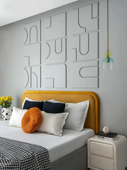 This bedroom showcases playful yet sophisticated design with a custom 3D wall art piece above a mustard-yellow headboard. The colorful glass pendant light adds a whimsical touch, creating a space that is both fun and stylish.