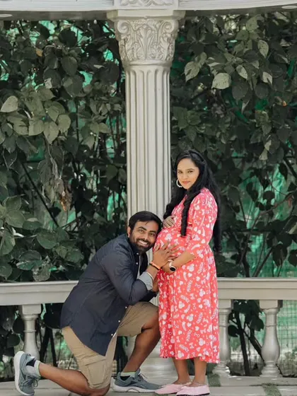 A joyful and classic maternity pose, with the father-to-be kneeling to embrace the baby bump.