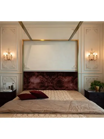 The master suite's four-poster bed, custom-made by my team, is the centerpiece of the room. The rich wine-colored velvet headboard contrasts beautifully with the light, mother-of-pearl finished wall panels.