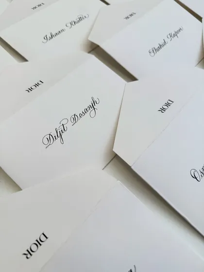 Another shot of the Dior notecards, this time showing the name of Diljit Dosanjh. Each one is written with care and precision.