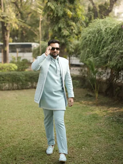 Dressed to impress without the stress. Our client rocks this stylish pastel blue open jacket Indo-Western outfit for his special occasion.