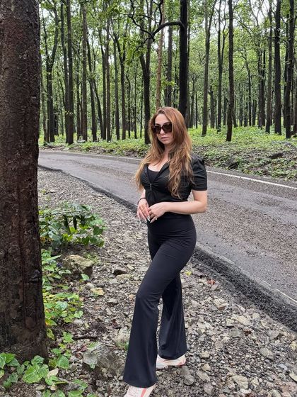 A confident stance in my all-black travel outfit, proving that you can look chic even in the middle of nature.