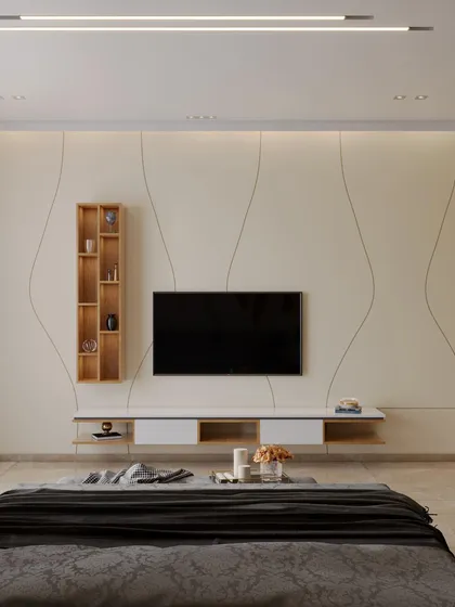 A minimalist TV wall in a bedroom, featuring subtle, flowing lines etched into the beige panels. A floating console with veneer accents adds a touch of natural warmth to the clean and serene design.