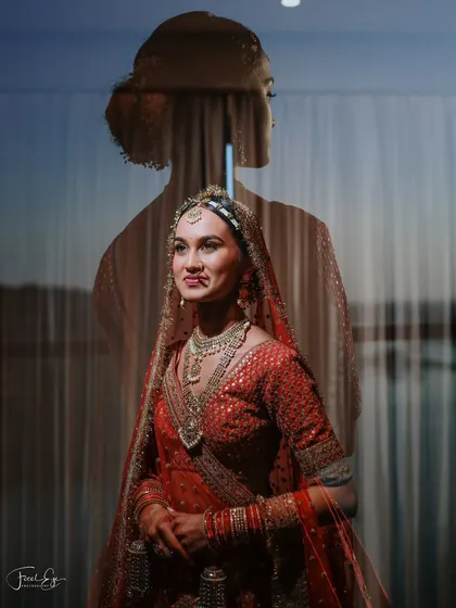 A creative double-exposure portrait, blending the bride's silhouette with her forward-facing image. This artistic technique adds depth and tells a story of introspection.