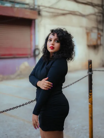 A portrait that captures a moment of quiet confidence on a city street. The out-of-focus background and the model's pose create an intimate and compelling image.