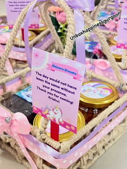 A close-up of a unicorn jute basket, highlighting the "Unicorn Dreams" thank you card and the custom-labeled treat jars.