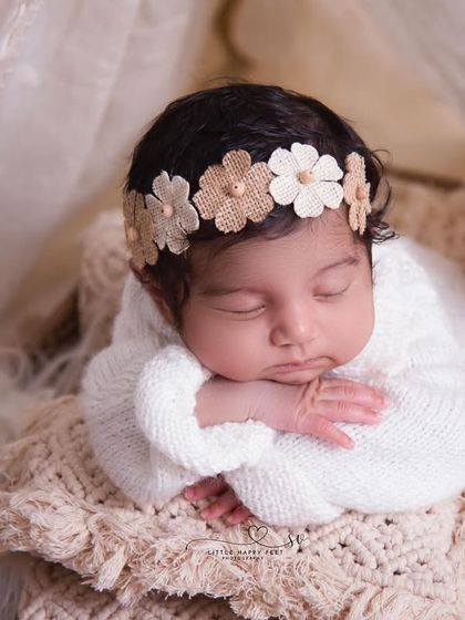 Our little boho girl. The cream-colored wrap, macrame blanket, and dried floral headband come together for a warm, earthy, and stylish portrait.