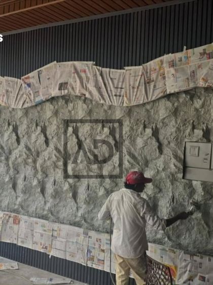 This photo shows my team during the installation of a PU stone accent wall. You can see how we carefully apply the finish over the panels to create a seamless, natural rock texture.