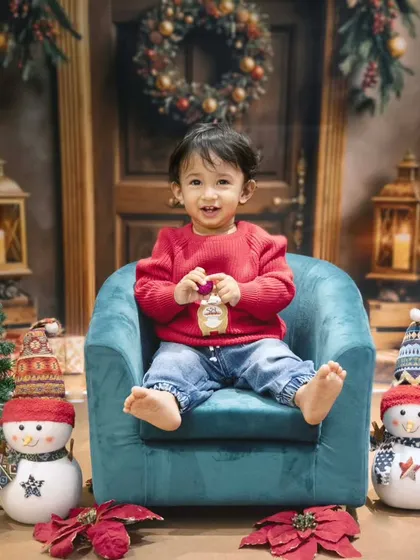 This little cutie is ready for Christmas. My holiday mini-sessions feature festive backdrops, props like snowmen and Santa mail, creating a magical winter wonderland.