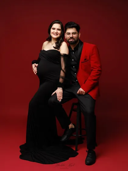 A sophisticated studio portrait of an expecting couple. The formal attire and classic posing create an elegant and timeless image you will cherish forever.