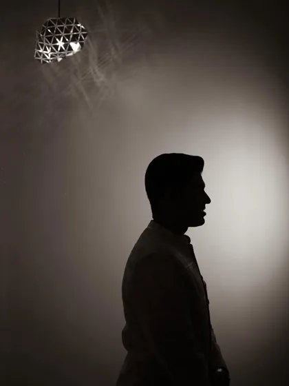 A creative silhouette of the groom, his profile outlined against a single spotlight, creating a moody and sophisticated portrait.