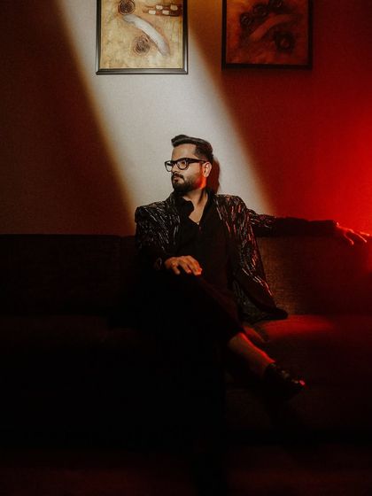 A moody and intense groom portrait. The play of light and shadow across his face and suit creates a powerful, cinematic look, full of character.