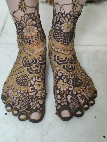 A detailed view of a heavy bridal foot design, with intricate patterns covering every part of the feet.