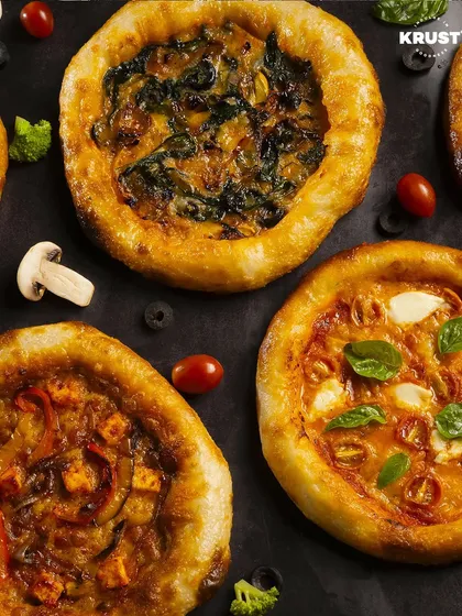 A beautiful spread of personal-sized pizzas, each with unique toppings from spinach and mushroom to classic Margherita. This is what a successful day at our pizza workshop looks like.