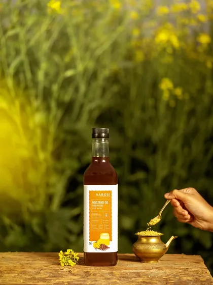 A bottle of Barosi's mustard oil set against a backdrop of mustard fields. This image tells a clear story of the product's origin, highlighting its natural and pure qualities.