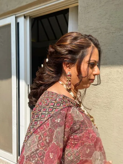 A side view of the bejeweled braid, showing how the style frames the face while keeping the hair pulled back. The soft tendrils add a touch of romance.