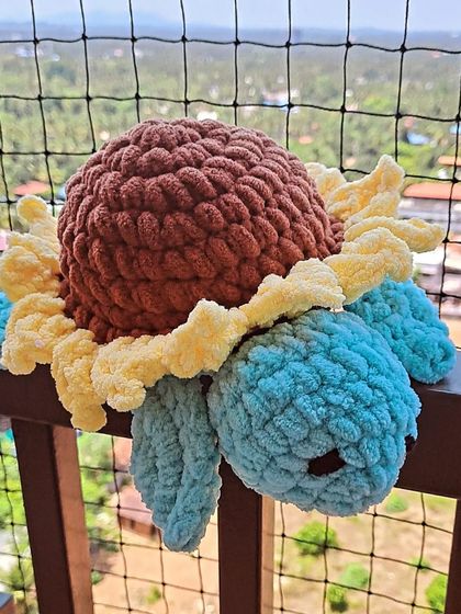 A sunflower plush turtle, made with a blue body.