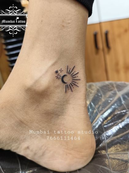 A minimal sun, moon, and stars tattoo on the ankle. This is a popular placement for small, celestial designs that carry personal meaning.