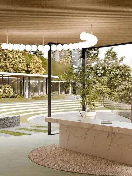 The reception area of the resort, with a marble desk and an open-air design that looks out onto the terraced landscape and fire pit.