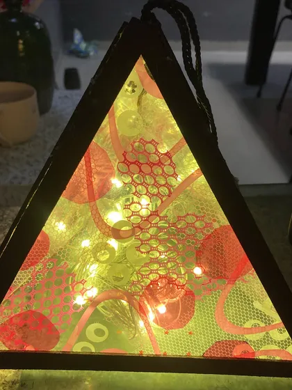 Our festival workshops are a chance to create something truly special. This beautiful triangular lantern, lit from within, was crafted by a student during our Diwali celebration, blending traditional themes with contemporary design.