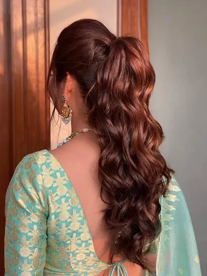 A wavy ponytail for the bride's sister. It's an elegant and chic choice that complements the main bridal party without being over the top.
