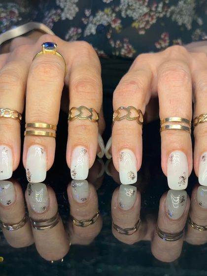 A lovely white manicure with scattered silver foil flakes for a touch of texture and shine.