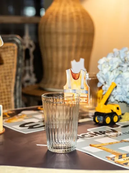 A custom "Caution" sign with the birthday boy's name and age, paired with a tiny safety vest drink charm.