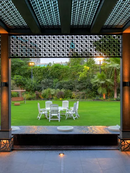A view from the shaded comfort of a custom pergola, looking out onto an expansive green lawn. This composition of architecture and landscape shows how we frame nature to create inviting, functional, and beautiful outdoor living areas.