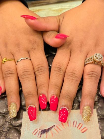 A classic party combination of bright red and gold. This set features red nails with gold glitter accent nails and rhinestone details at the cuticle.