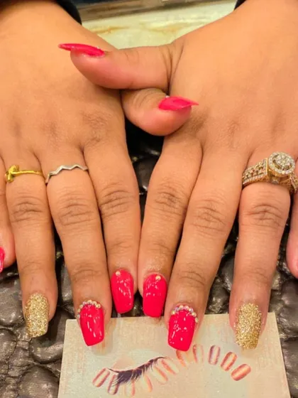 A classic party-ready combination of bright red and gold. This set features red nails with gold glitter accent nails and rhinestone details at the cuticle.