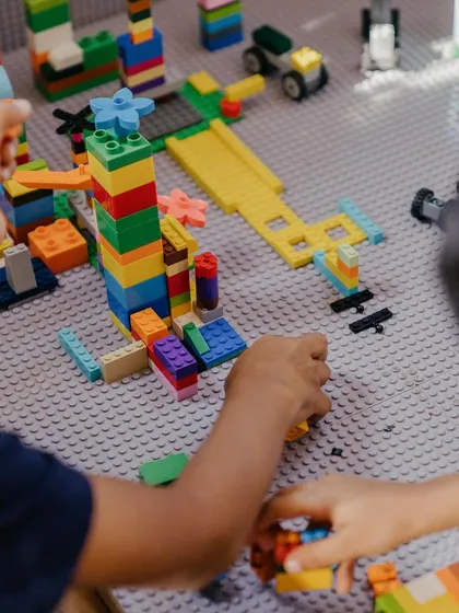 Two children collaborating on a complex Lego creation. The Makerspace is designed for this kind of teamwork, where shared ideas lead to bigger and better builds.