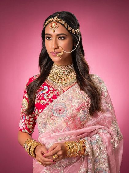 A close-up on the jewelry and the detailed embroidery of the blouse, showcasing the craftsmanship of this bridal look.